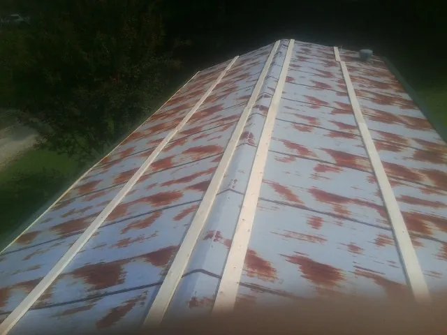 Rusted metal roof panels with new wood purlins before replacement — Storm Damage Roof Repair in Swayzee by Roofing Brothers