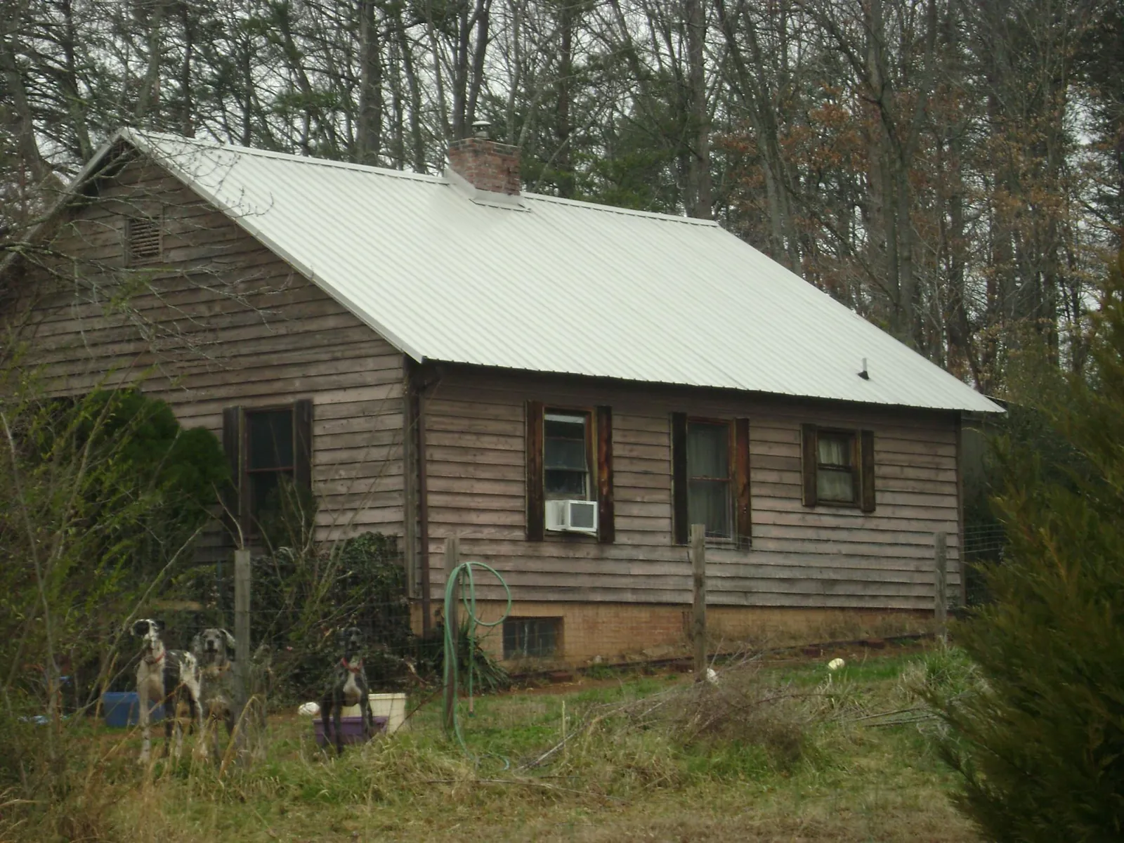 White metal roof on an old wood sided farmhouse, from a Metal Roof Installation job in Swayzee